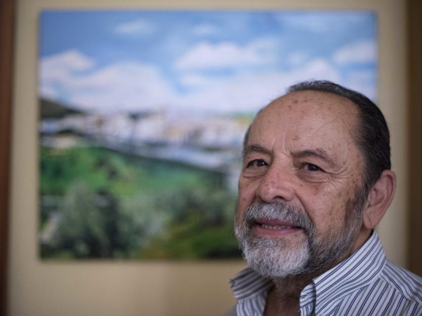 El sacerdote delante de uno de los cuadros que le regaló un antiguo recluso que pasó por su casa.