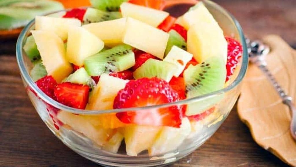 Una macedonia de frutas con kiwi, fresa y manzana.