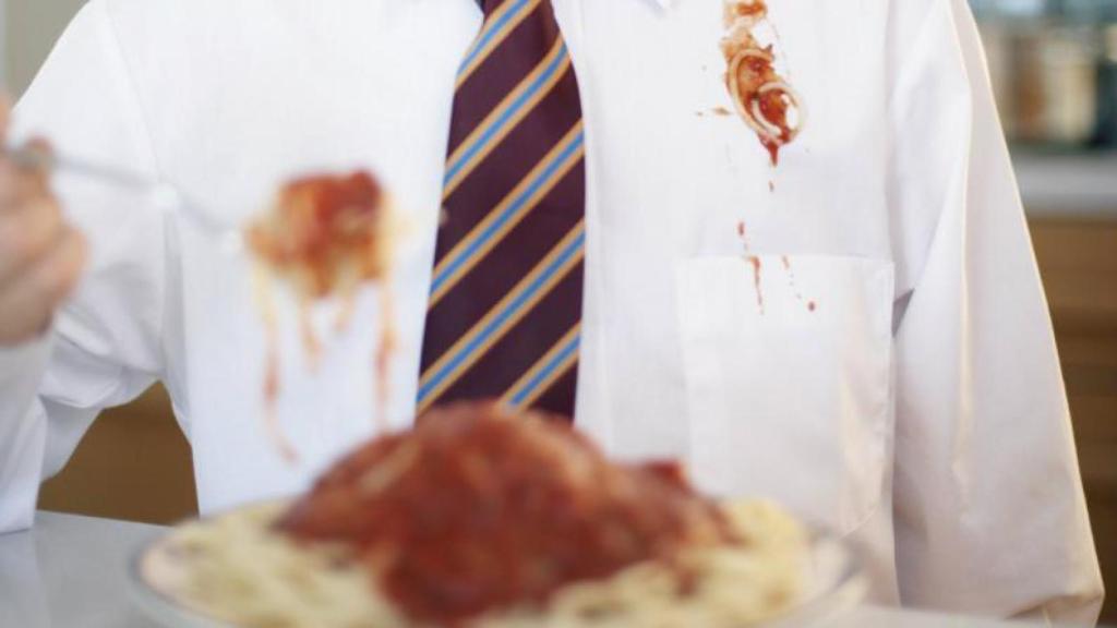Un señor con una camisa blanca impoluta manchada de tomate.