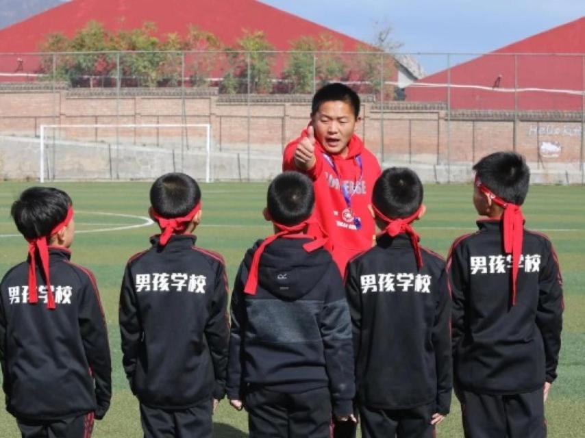 Tres niños reciben órdenes en el campamento.
