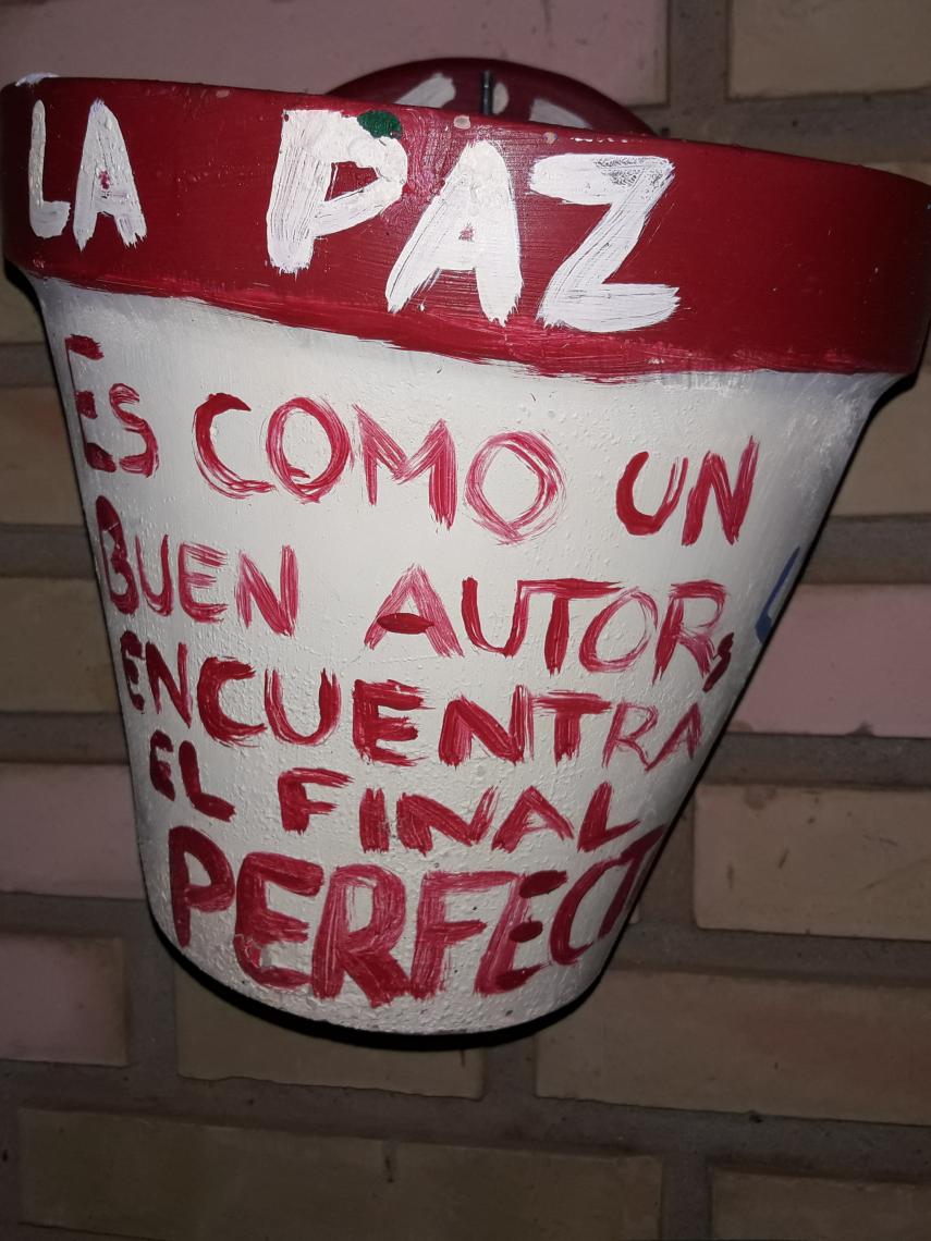 Una maceta antigua a favor de la paz en la entrada del instituto del detenido por matar a su madre.