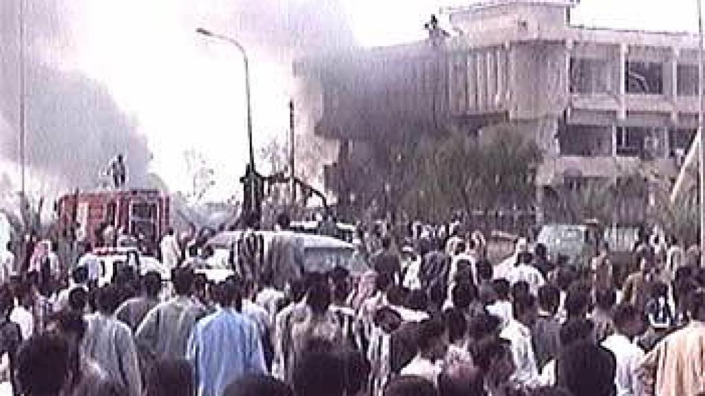 Cientos de curiosos se arremolinan ante la base italiana en Nasiriyah, tras el atentado de noviembre de 2003.