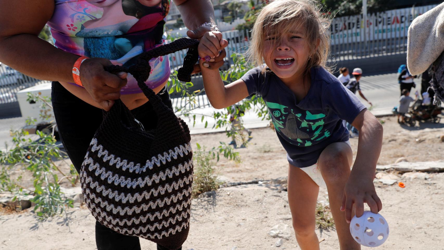 Una niña migrante de Honduras llora después de escapar del gas lacrimógeno. /Reuters