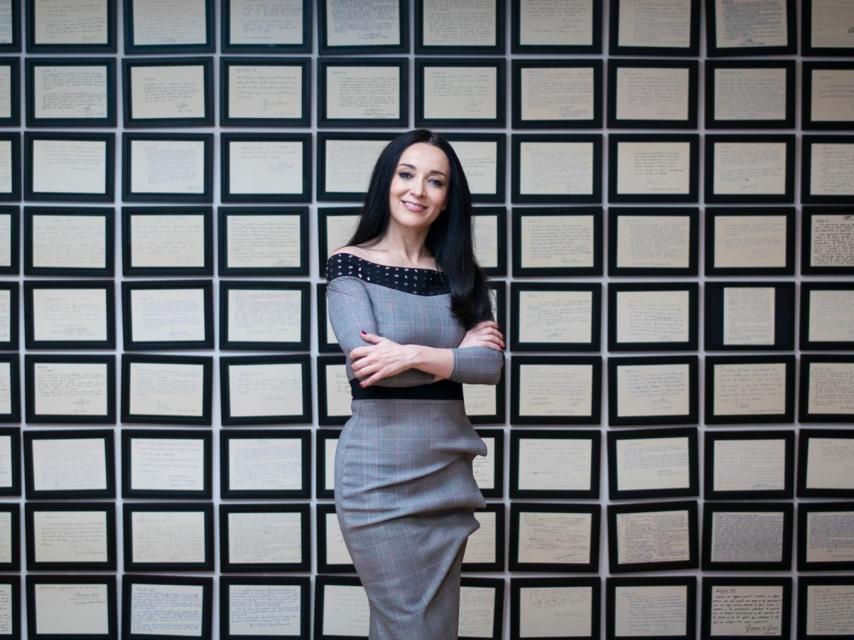 Cruz Sánchez de Lara delante del mural formado por los artículos de la primera Constitución autógrafa y coral.