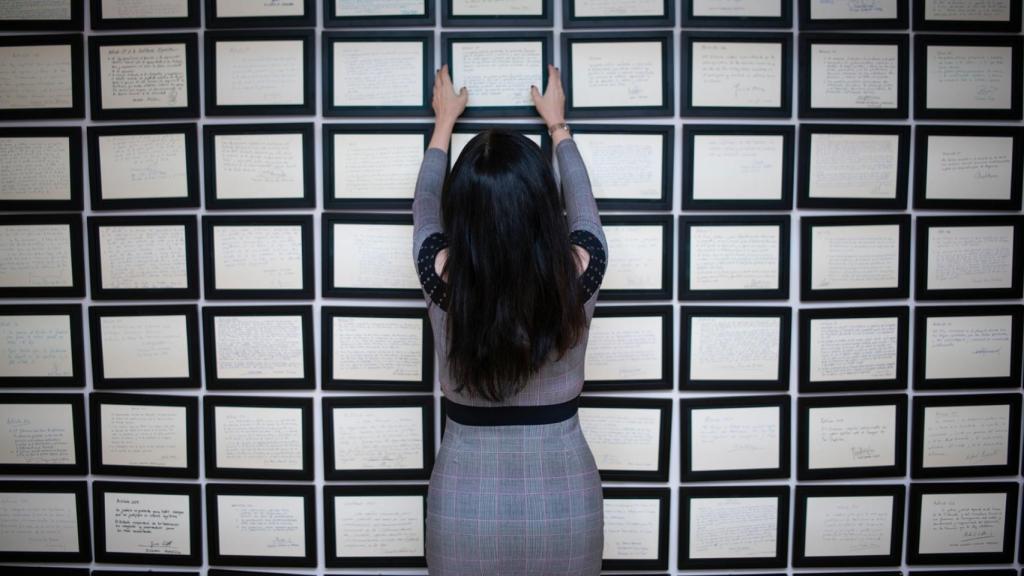 La abogada Cruz Sánchez de Lara coloca en el mural de la primera Constitución autógrafa y coral.