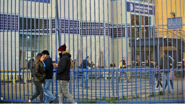 Solicitantes de asilo ante las verjas de la comisaría central de extranjería de Aluche, en Madrid.
