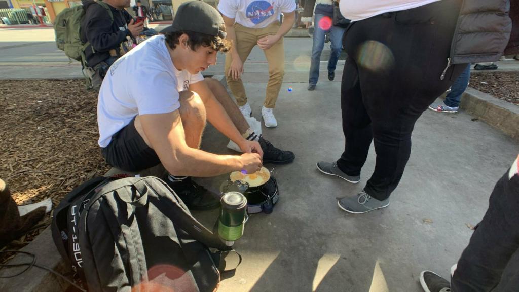 Nick y Johnny, estudiantes de la Universidad de San Diego, cocinan para los migrantes de la caravana.
