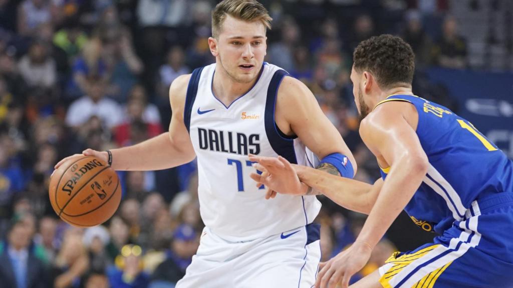 Luka Doncic bota el balón ante Stephen Curry