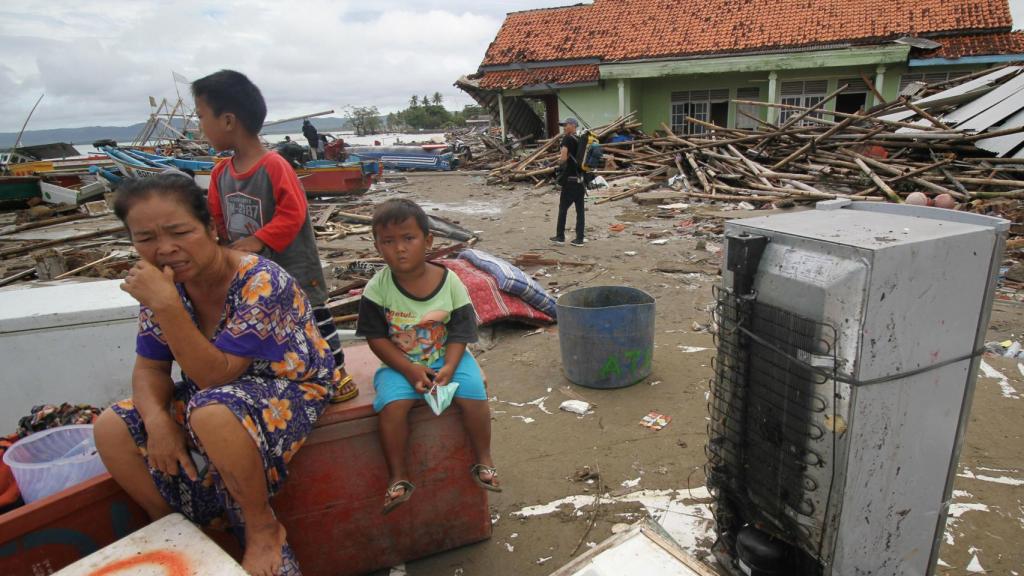 En la playa de Pandelang, una mujer y sus hijos entre sus enseres.