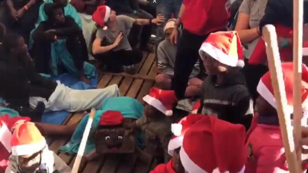 Los niños del 'Open Arms' celebran el Caga Tió en cubierta durante la Nochebuena en alta mar.
