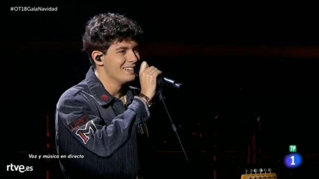 Alfred sobre el escenario cantando.