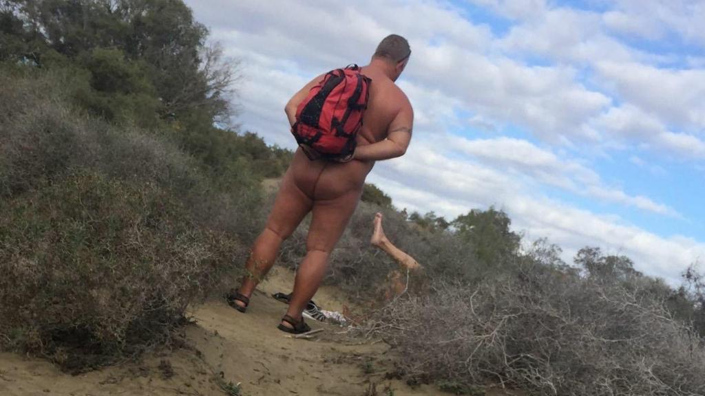 Un mirón observa cómo una pareja tiene sexo en una duna de Maspalomas, Gran Canaria.