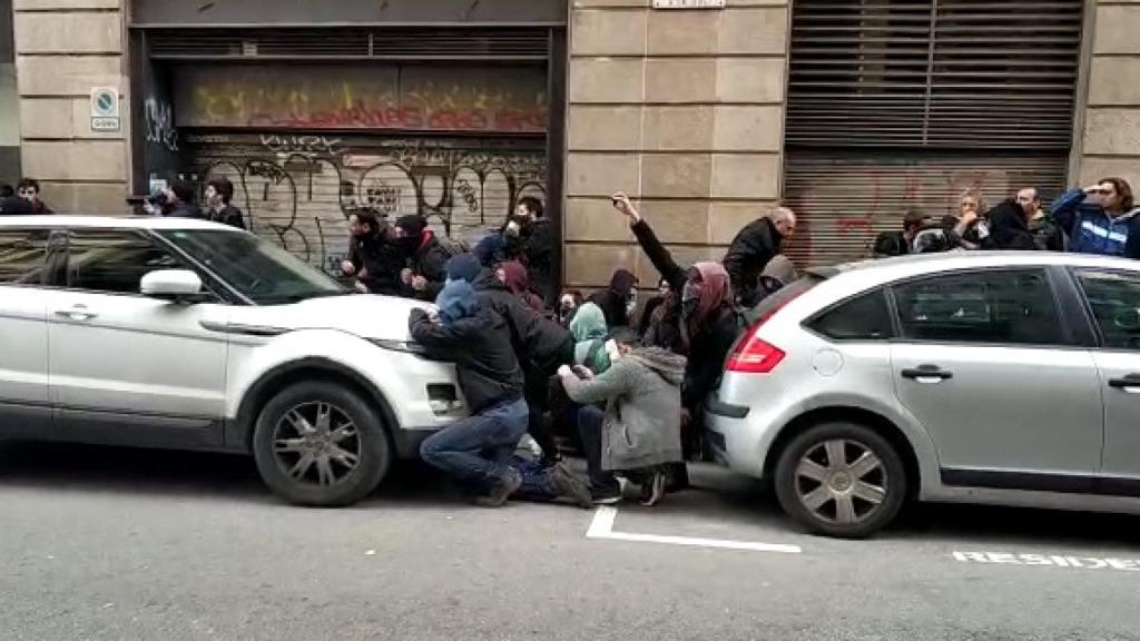 Varios encapuchados y con la cara tapada frente a los agentes en la calle Fustería.