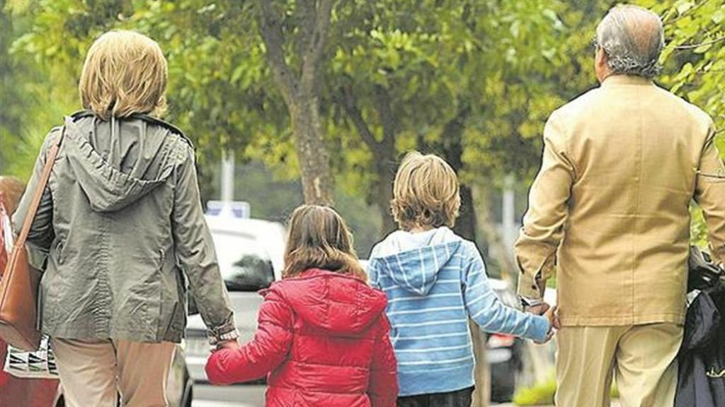 Pareja de abuelos paseando con sus nietos