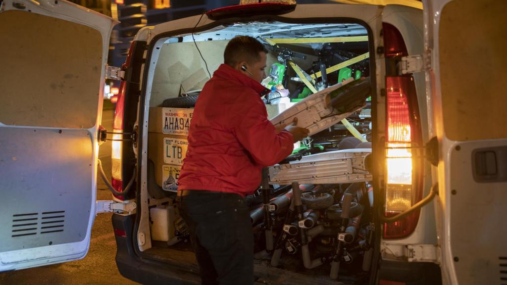 Karel, uno de los 'hunters' (cargadores de patinetes de Madrid), los mete en su camioneta.