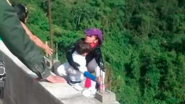 En la imagen, momento en el que la mujer se va a precipitar por el puente con su hijo en brazos.