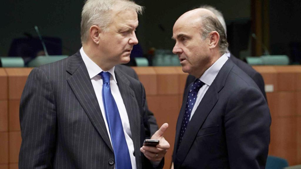 Rehn conversa con Luis de Guindos durante su etapa de comisario de Asuntos Económicos