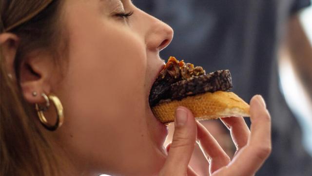 En la imagen, la periodista de EL ESPAÑOL probando la morcilla hecha con su propia sangre