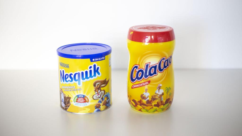 Un bote de Nesquik y otro de Cola Cao frente a frente.