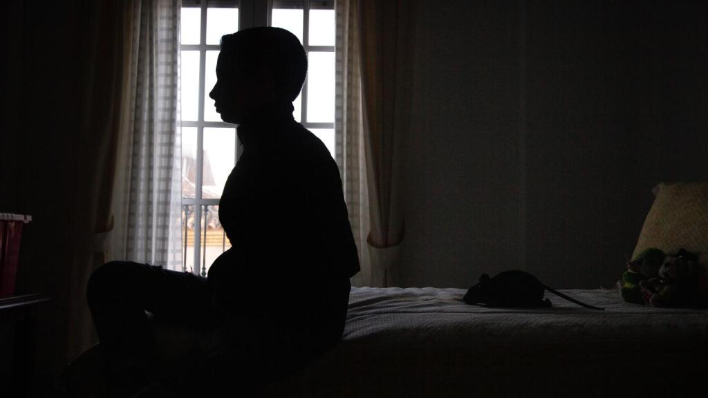 Antonio sentado sobre la cama de su dormitorio.