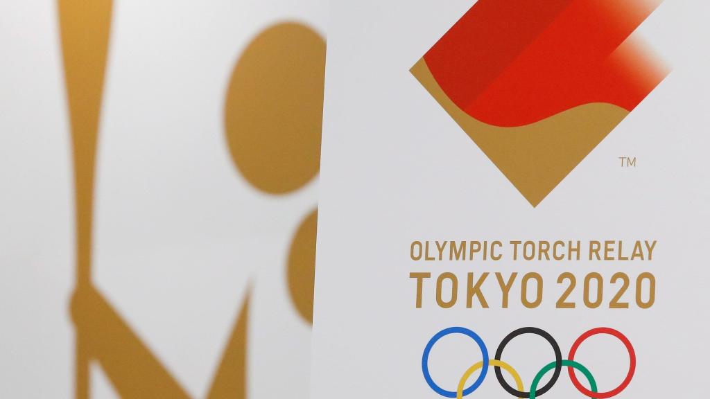 Miko Takeda, miembro del comité de relevos de la antorcha olímpica de los Juegos de Tokio 2020, muestra el emblema durante la ceremonia de presentación