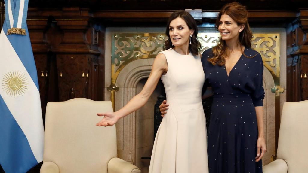 La Reina, con su vestido color crema, posando junto a Awada.