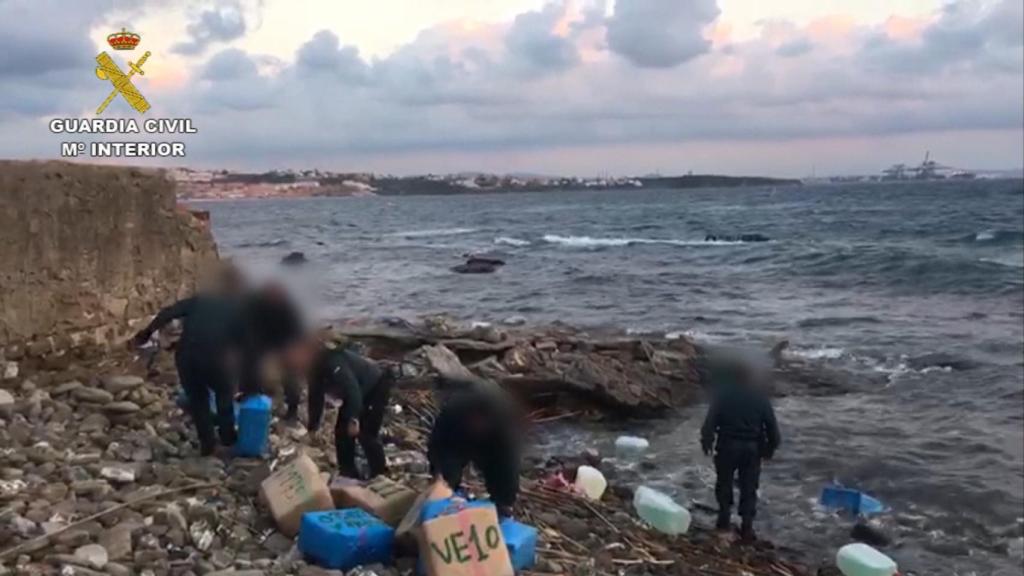 Agentes de la Guardia Civil se incautan de fardos de hachís.