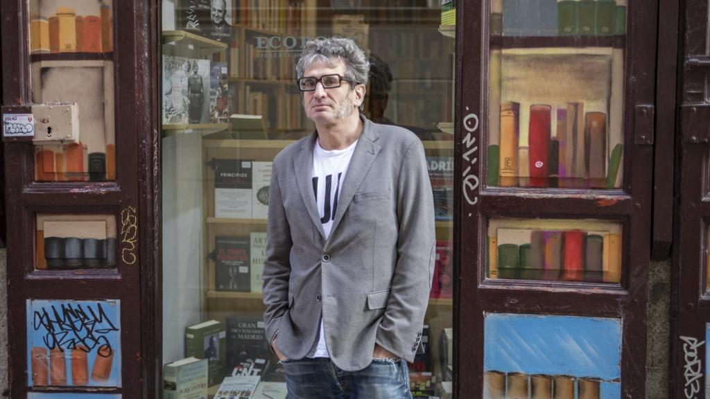 Camilo de Ory posa delante de la puerta de una librería.