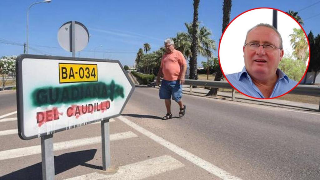 Un hombre pasa por delante de una señal que indica hacia Guadiana del Caudillo (Badajoz).