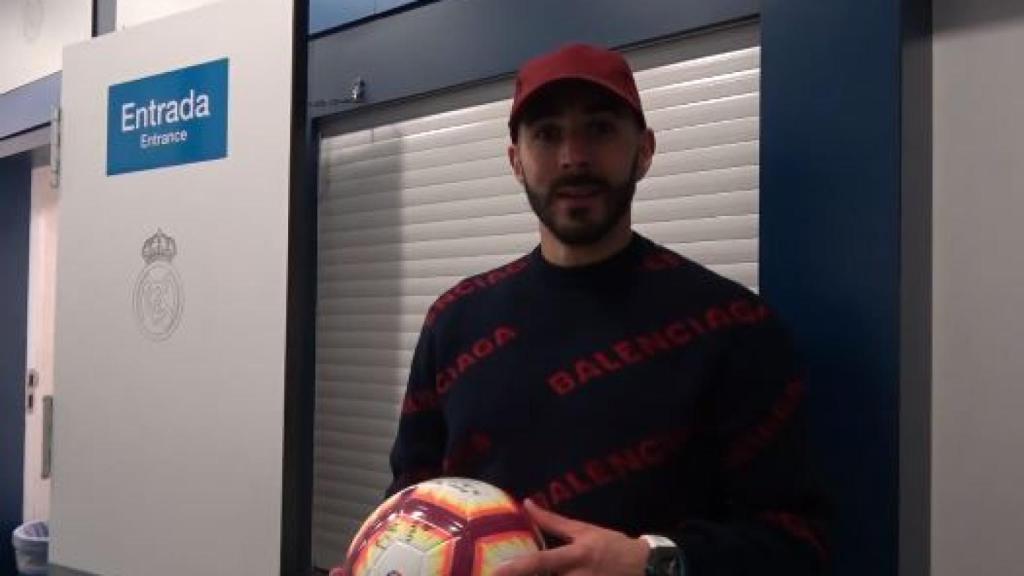 Benzema junto al balón con el que anotó el hat-trick