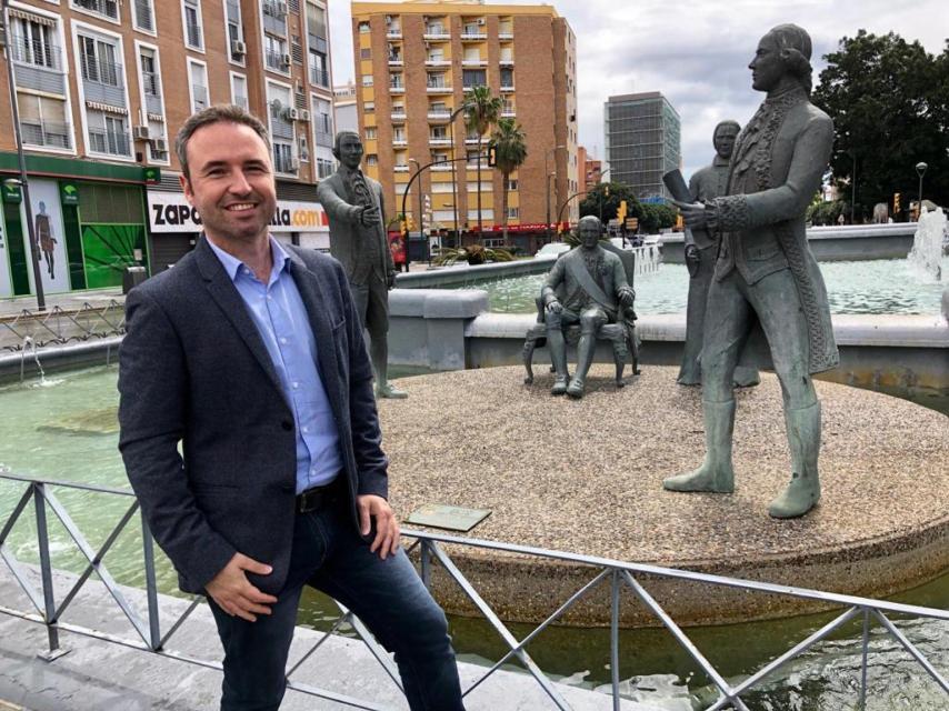 Guillermo Díaz delante de la estatua a Bernardo de Gálvez y su familia en Málaga.