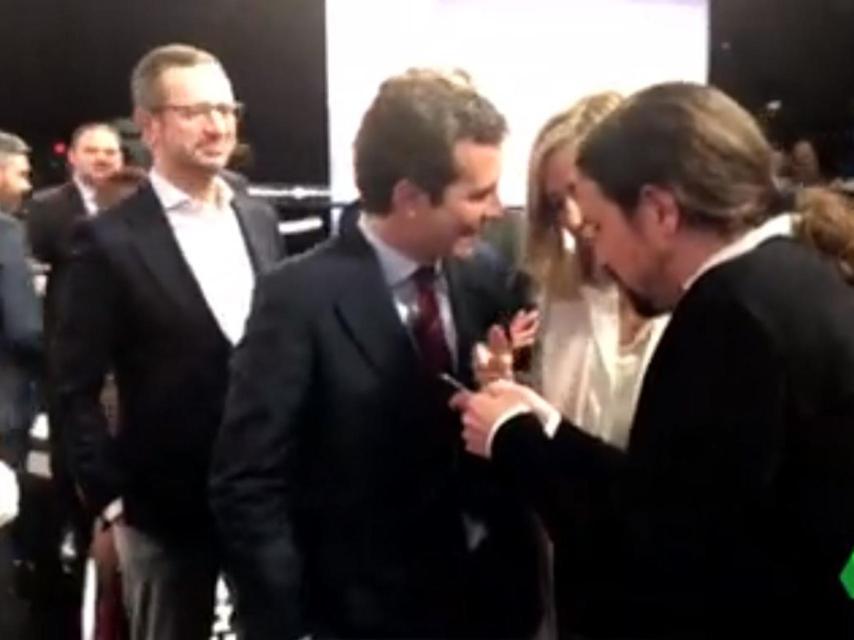 Pablo Iglesias le enseña una foto de sus hijos a Pablo Casado y a su mujer, Isabel Torres, tras el debate.