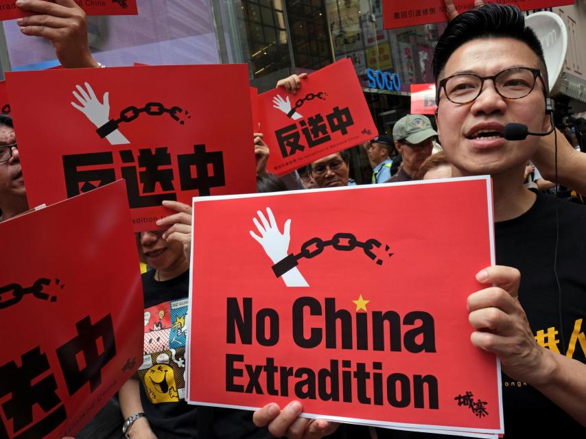 Uno de los manifestantes porta una pancarta en contra de la extradición.