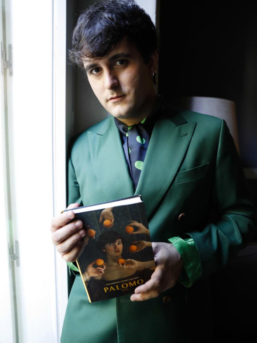 El diseñador posando con su libro en la mano.