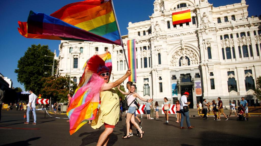 Jóvenes corriendo por las calles de Madrid con el Ayuntamiento de fondo.