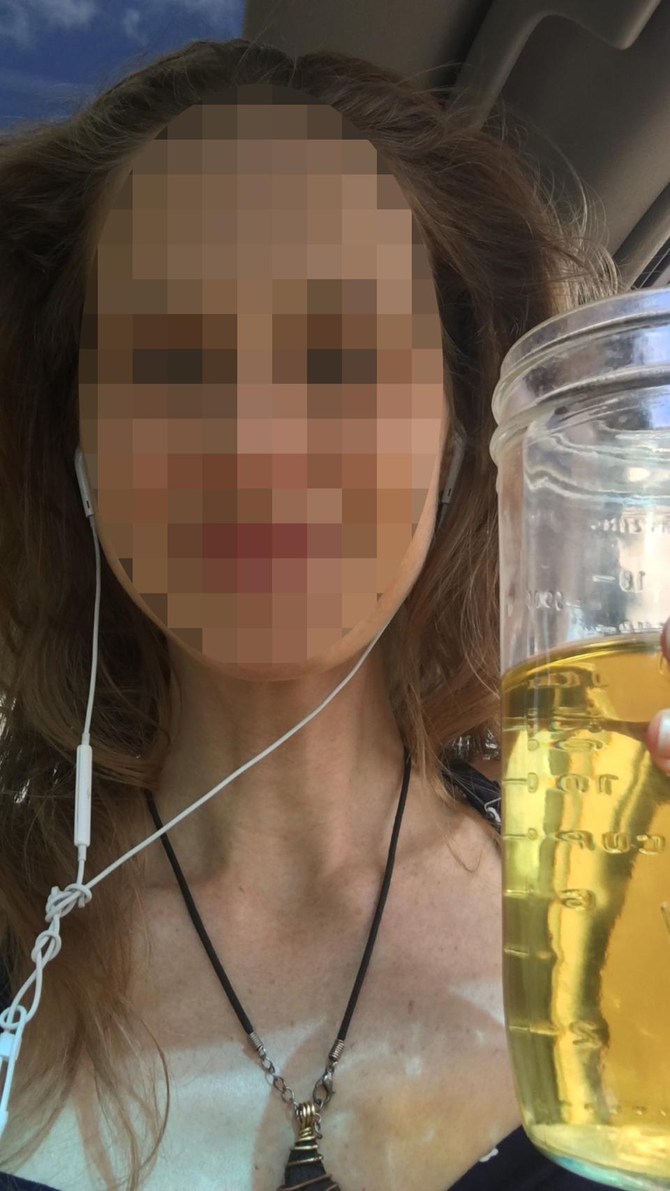 Una joven muestra orgullosa un vaso con orina.