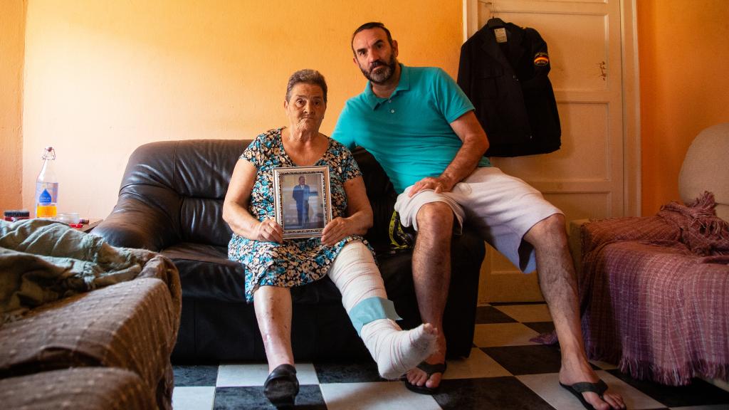 Cándida, con su hijo, junto al uniforme de su difunto marido.