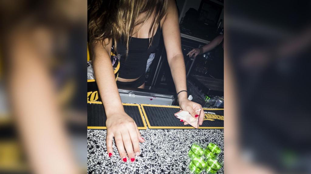 La reportera de EL ESPAÑOL sirviendo chupitos en el bar en Magaluf