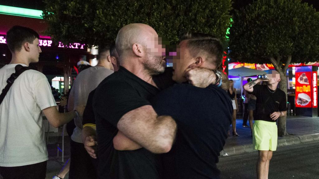 Un segurata intentando tranquilizar a un joven frente a un bar en Punta Ballena