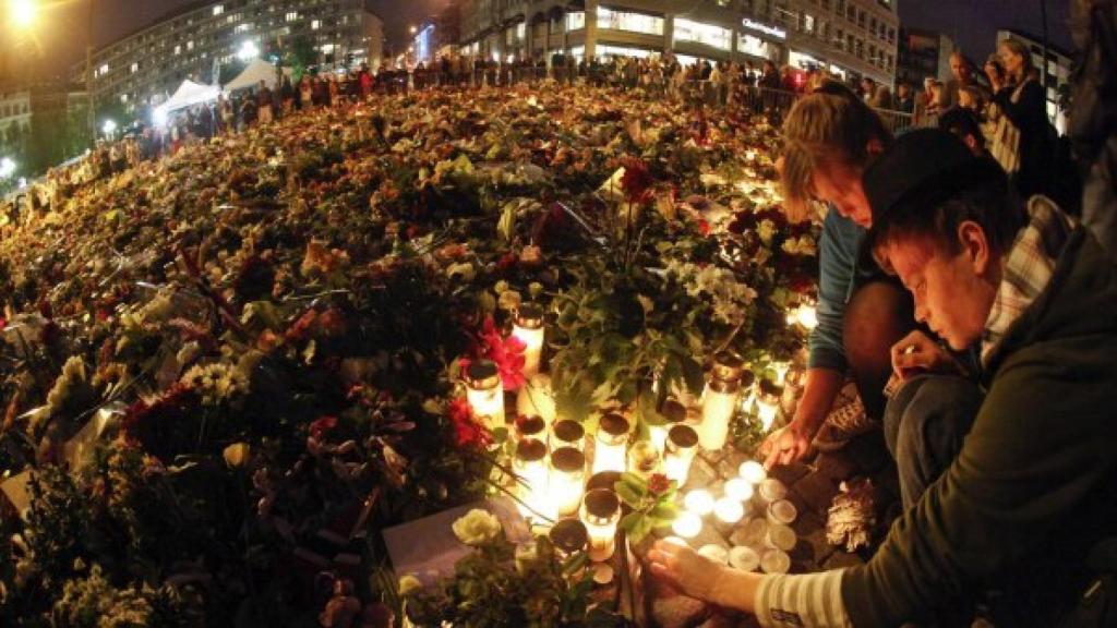 Jóvenes ponen velas a los fallecidos.