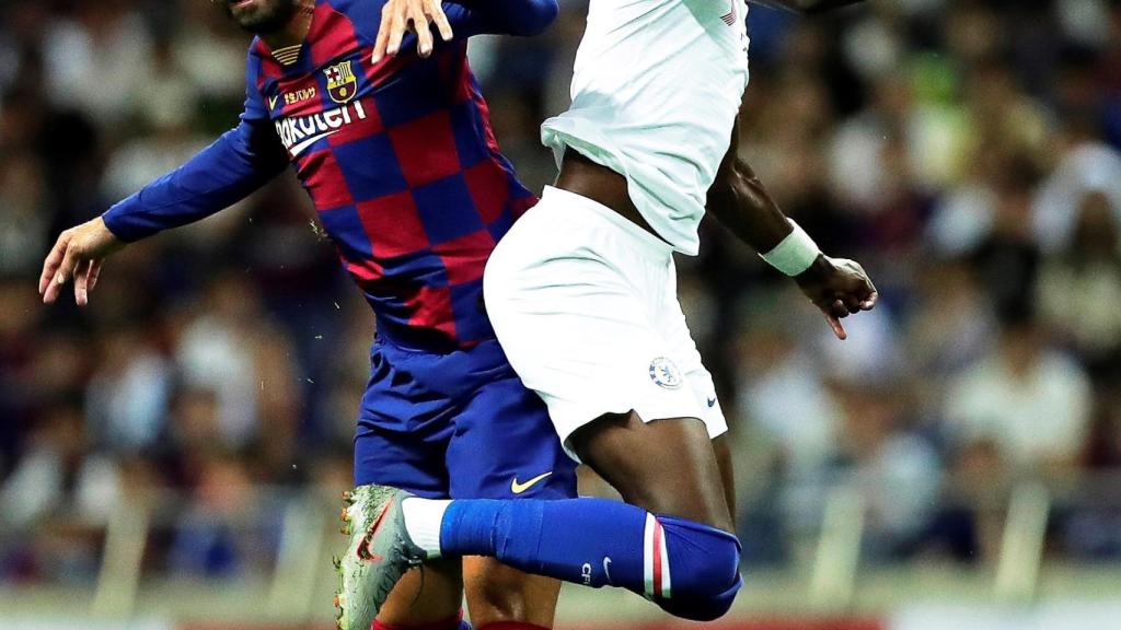 Piqué y Abraham pelean por un balón