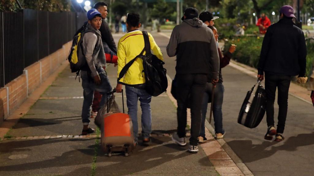 Un grupo de venezolanos camina por una acera cercana al Terminal de Transporte de Bogotá