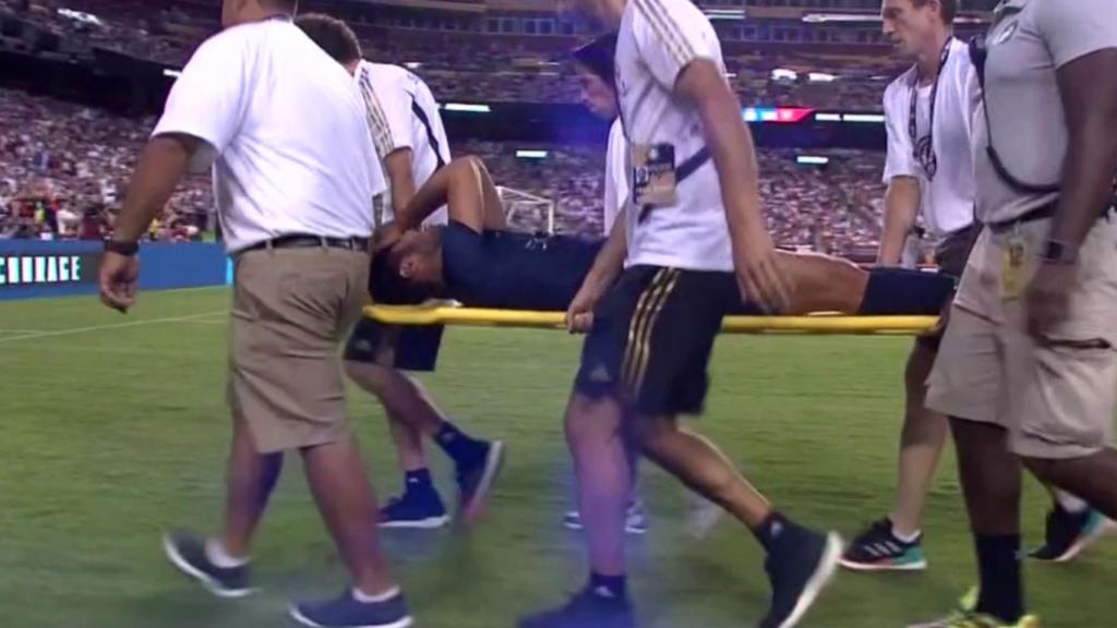 Marco Asensio se retira en camilla durante el partido frente al Arsenal