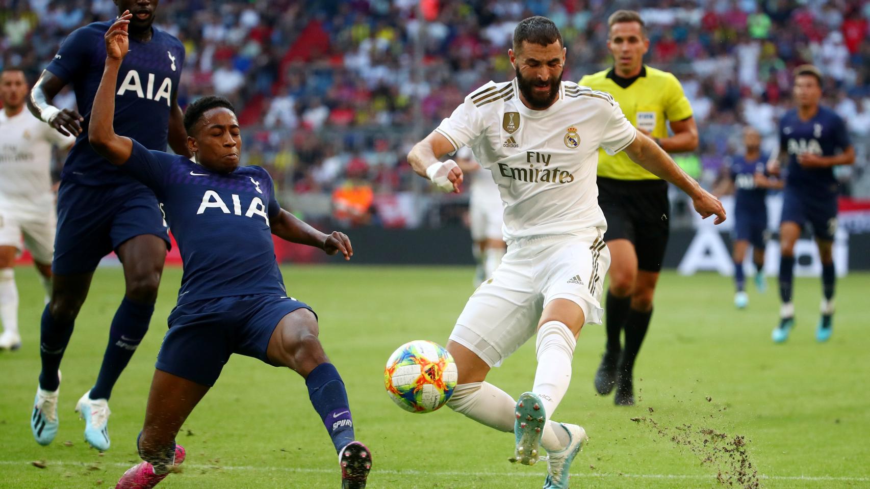 Karim Benzema dispara con un jugador del Tottenham delante
