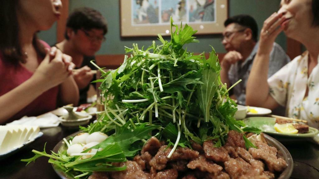 Unas mujeres ante un plato de comida.