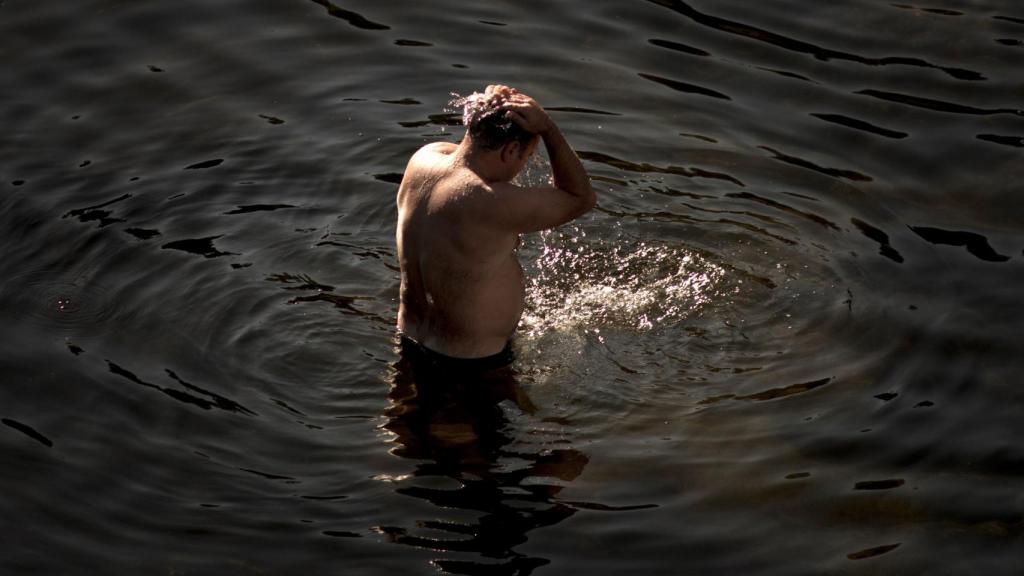 Un hombre se refresca en el Miño.