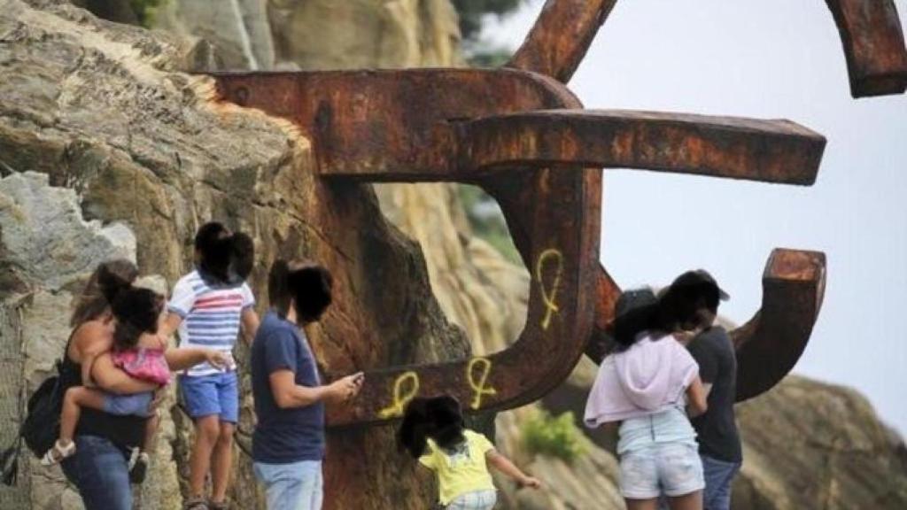 Una de las esculturas del Peino del Viento ha amanecido con pintadas de lazos amarillos.
