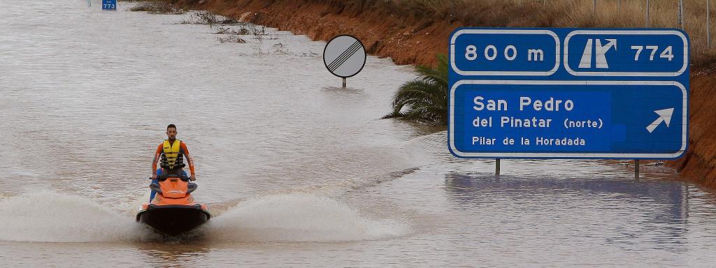 Un miembro de los servicios de rescate cruza en moto acuática la salida del túnel de la AP-7en Pilar de la Horadada (Alicante).