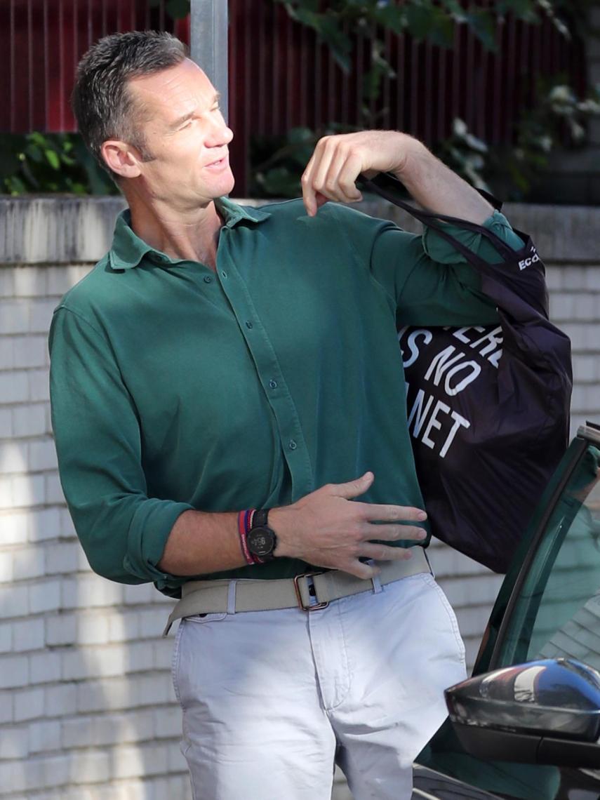 Iñaki Urdangarin con camisa verde, pantalón beige y bolsa de Ecoalf.