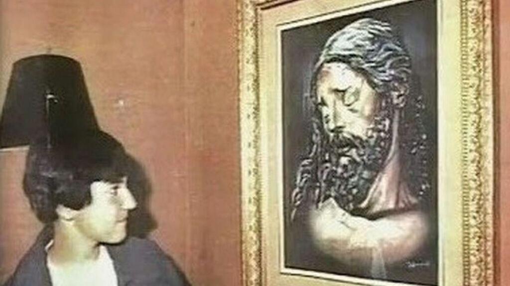 El niño pintor junto a uno de sus dibujos.